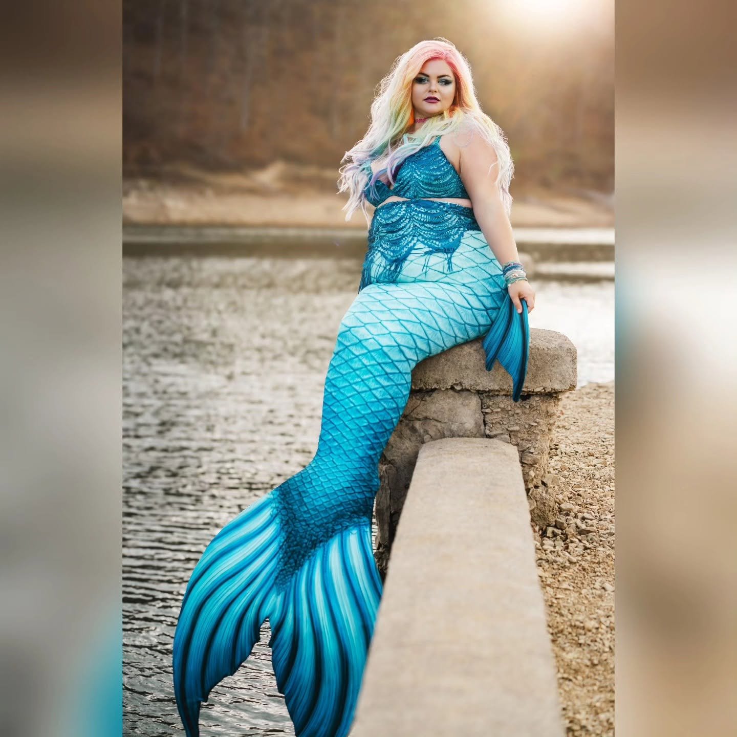 WhimSea Waves resting lakeside in a blue mermaid tail with flower hair accessories.